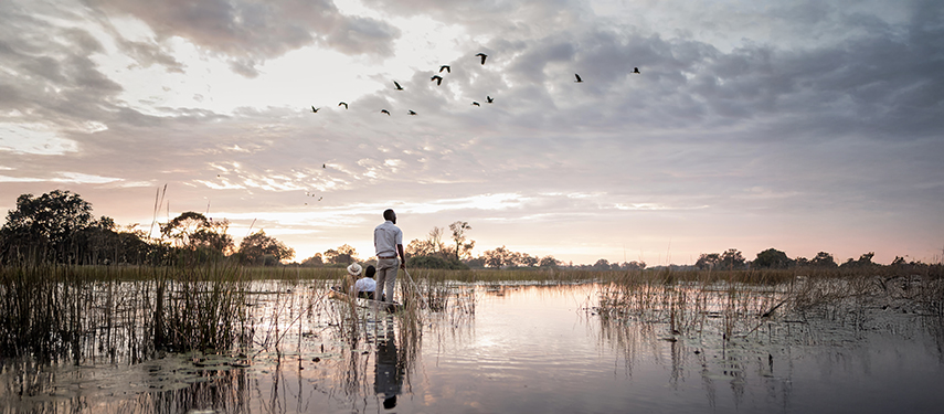 Tourist takes a mokoro canoe ride in the Okavango Delta, Botswana