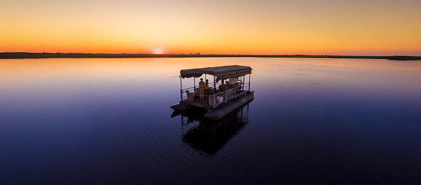 Fishing pontoon on the calm waters of the Linyanti River at sunset in Botswana