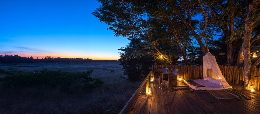 Twilight settles over the deck as lanterns light up a romantic open-air star bed.