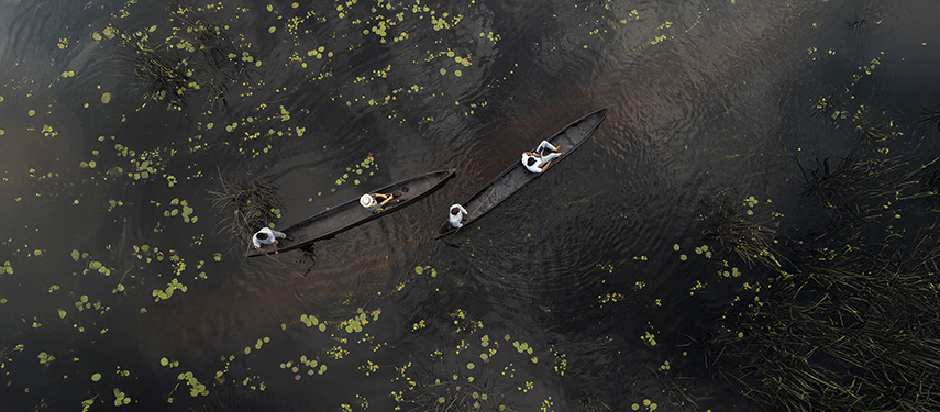 Tourists take a mokoro canoe ride in the Okavango Delta, Botswana