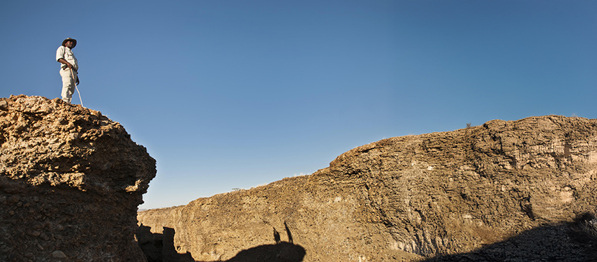 Guide stands on a clifftop overlooking a gorge in Namibia