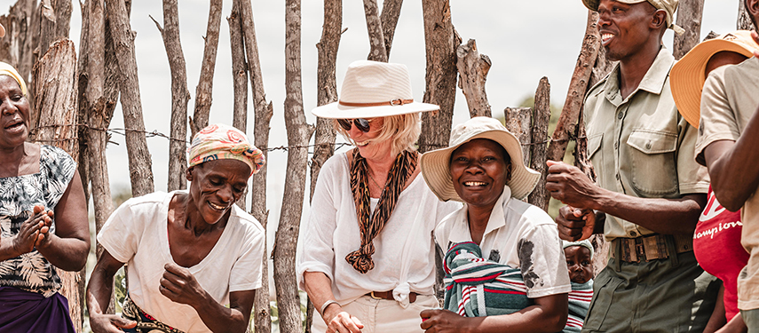 Guests sharing a joyful moment with local community members near Davison’s Camp