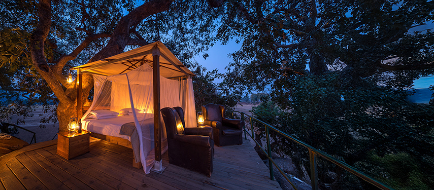 Star-bed platform with canopy and lanterns set up for an open-air sleep-out experience