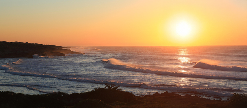 Vibrant sunset over the Indian Ocean, casting a golden glow on the waves.