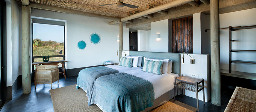 Interior of a stylish and airy suite featuring natural textures and coastal views.