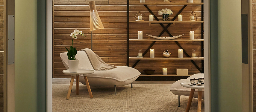 Serene relaxation space at Four Seasons Casa Medina spa with plush loungers, ambient candlelight, and natural wood panelling.