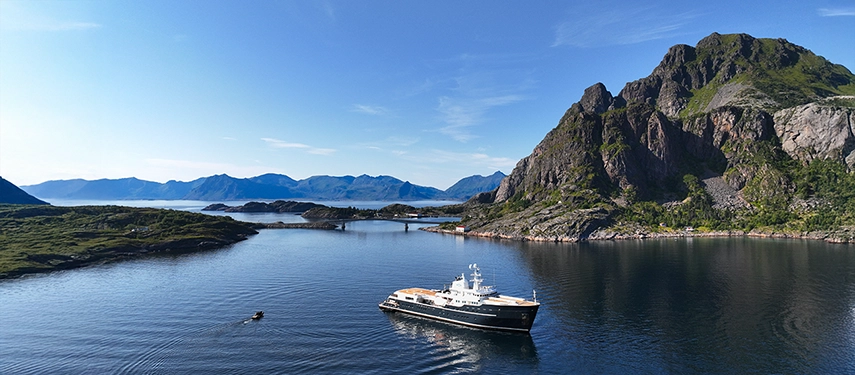 Aqua Lares anchored in a secluded Norwegian inlet surrounded by rugged coastal peaks.