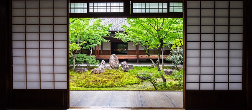 A tranquil Zen garden viewed through sliding shoji doors, showcasing balance, simplicity and contemplative Japanese design.