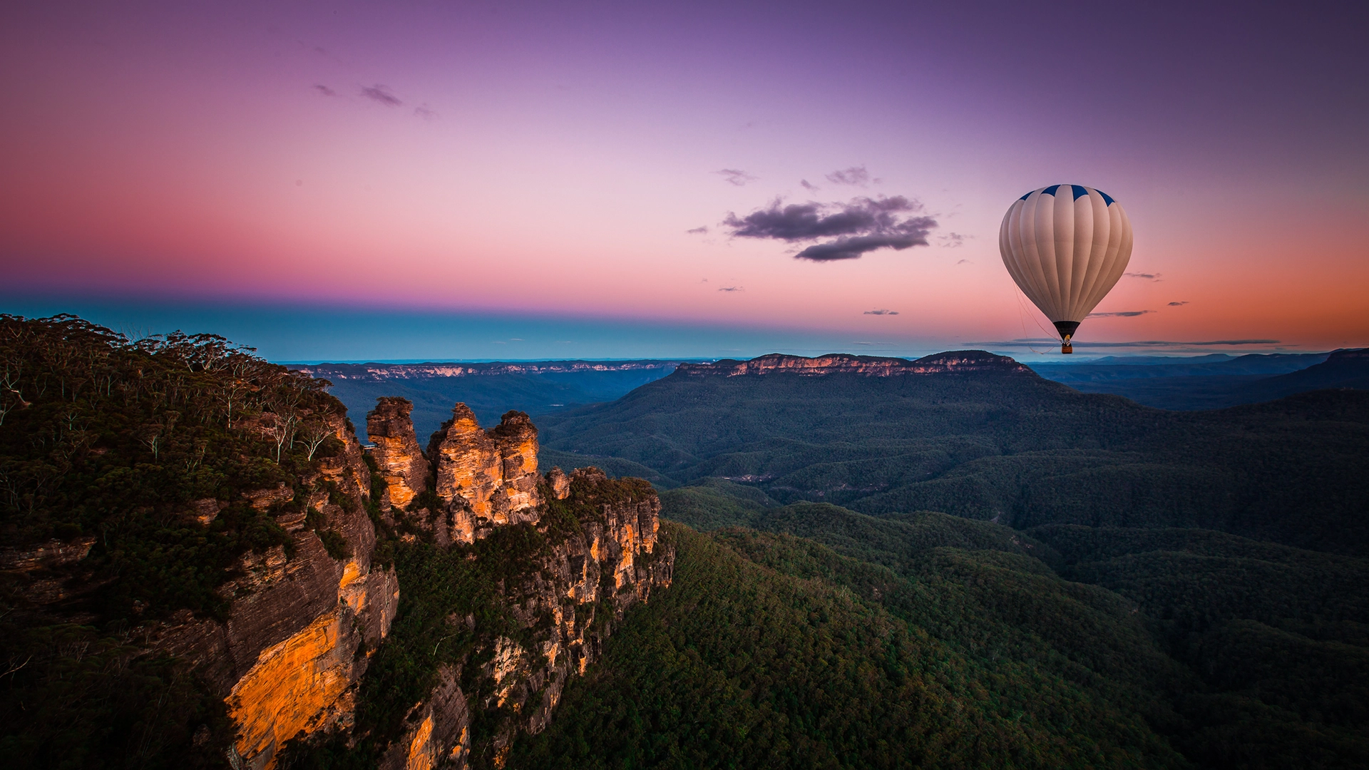 Hot-air balloon flying over the Blue Mountains in Australia at sunrise.