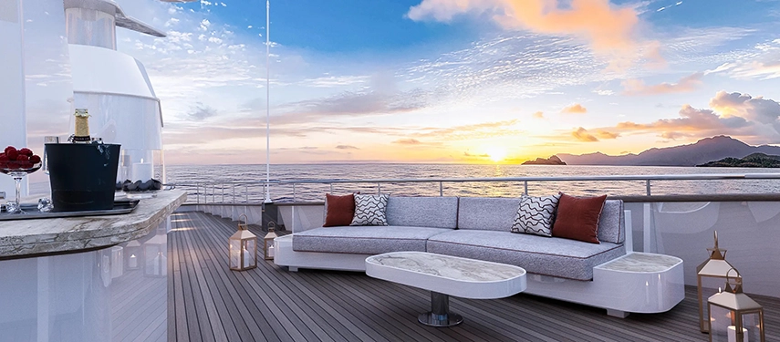 Elegant sun deck lounge with sofa seating, lanterns and sunset ocean views.