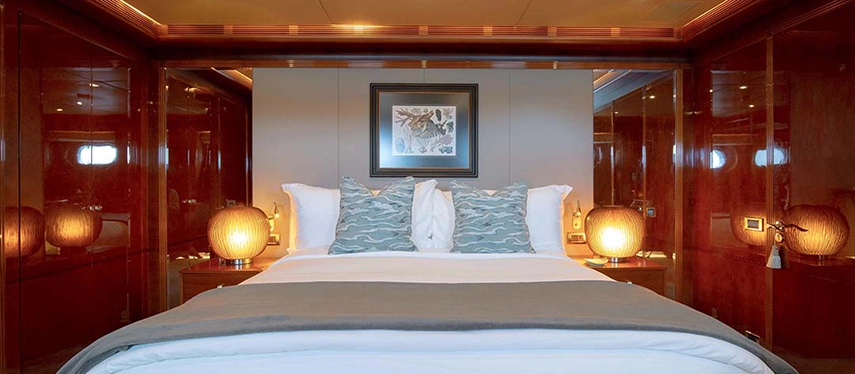 An elegant master suite on Aqua Mare with refined wood panelling, ambient lighting and soft neutral tones creating a calm maritime retreat.