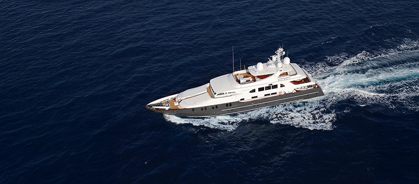 An aerial view of Aqua Mare slicing through deep blue seas, her wake trailing gracefully behind.