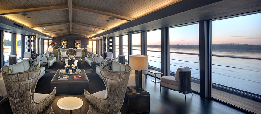 The sophisticated lounge and bar aboard Aqua Nera, featuring elegant furnishings and panoramic river views.