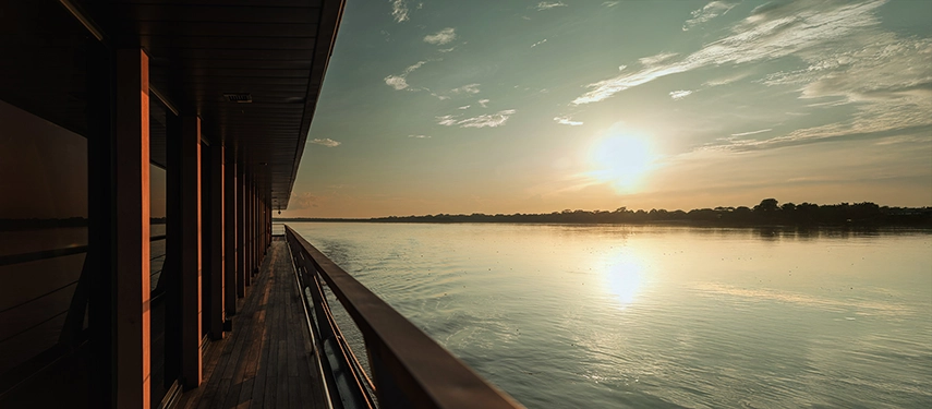 Golden sunlight reflecting on the river as seen from Aqua Nera’s observation deck during a serene Amazon sunset.
