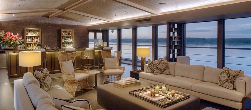 The elegant indoor lounge aboard Aqua Nera, featuring plush seating, warm lighting, and panoramic river views.