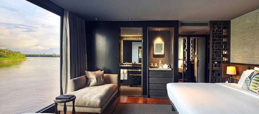 A spacious suite aboard Aqua Nera with floor-to-ceiling windows overlooking the Amazon and a stylish modern interior.