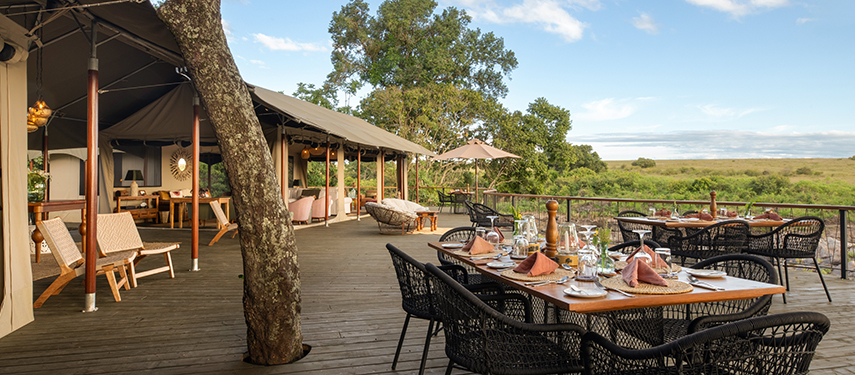 Outdoor dining area on a timber deck with sweeping views of the surrounding plains