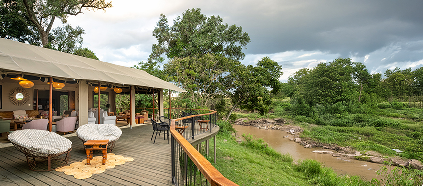 Relaxing deck with round loungers beside the Talek River.