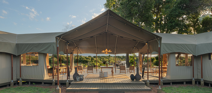 Exterior view of Rekero Camp’s main tented area surrounded by trees.