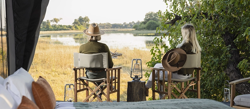 The interior of a Kweene Camp tent features organic textures and soft lighting for a comfortable, immersive wilderness stay.
