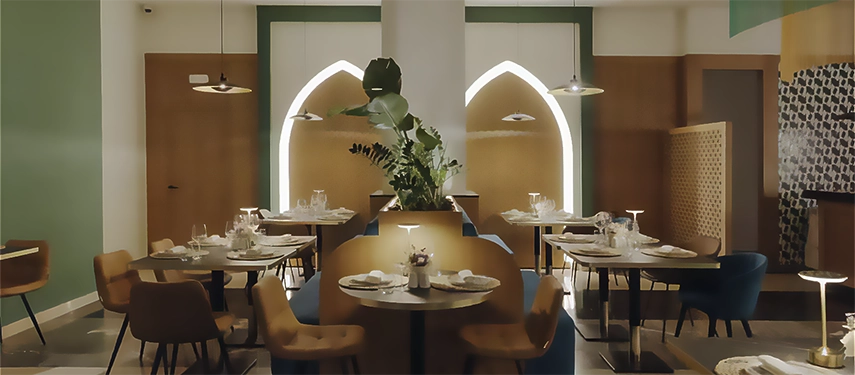 Elegant hotel dining area with soft lighting, modern chairs, and Moroccan-inspired arch designs creating a warm atmosphere.