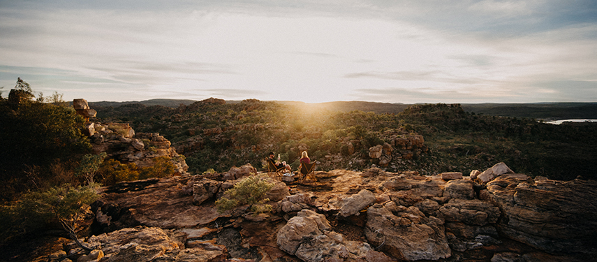 Guests enjoying sunset views from a rocky outcrop at Bullo River Station