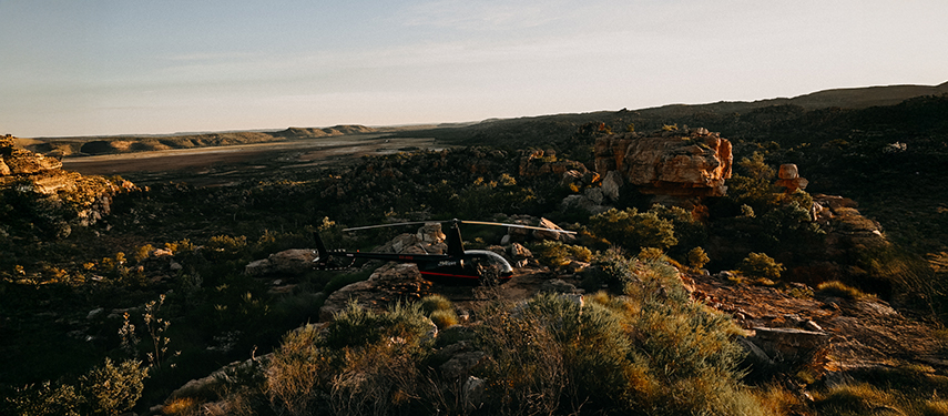 Helicopter perched on a rocky outcrop at Bullo River Station