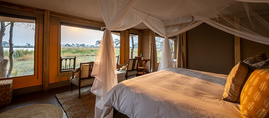 Romantic tent bedroom with mosquito net and lagoon views at Cha Cha Metsi.