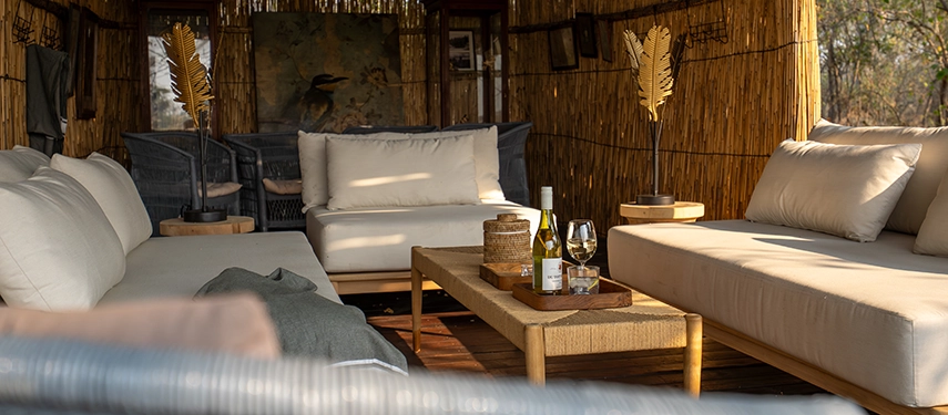 Shaded outdoor lounge with comfortable sofas and wine at Cha Cha Metsi.