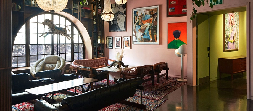 Eclectic lounge area at Gorgeous George decorated with vintage leather furniture and vibrant art.