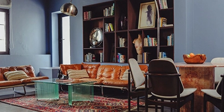 Sumptuous lounge area at Gorgeous George Hotel, Cape Town, with leather-bound couches in front of a book shelf.