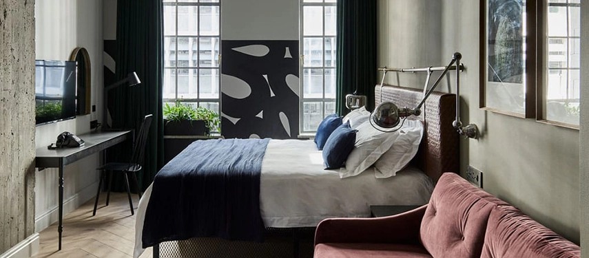 Bright, modern guest room at Gorgeous George with deep green curtains and designer accents.