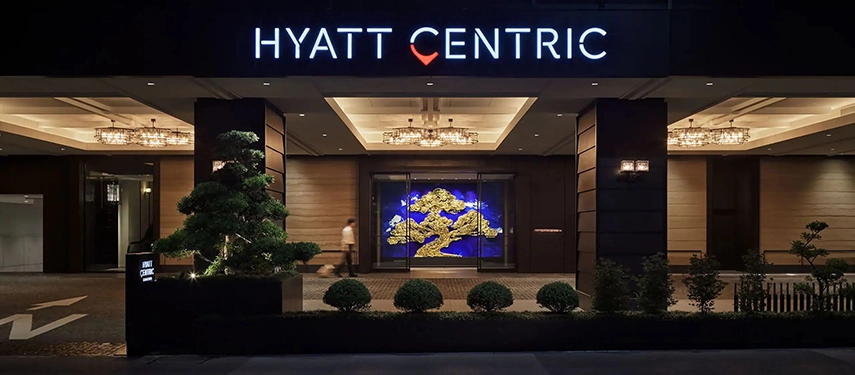 The illuminated entrance of Hyatt Centric Kanazawa at night, showcasing contemporary design in the heart of the historic city.