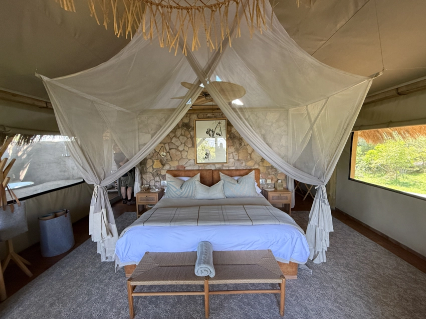 A beautifully appointed safari bedroom opens onto the bush, combining natural materials with refined comfort and a strong sense of place. 