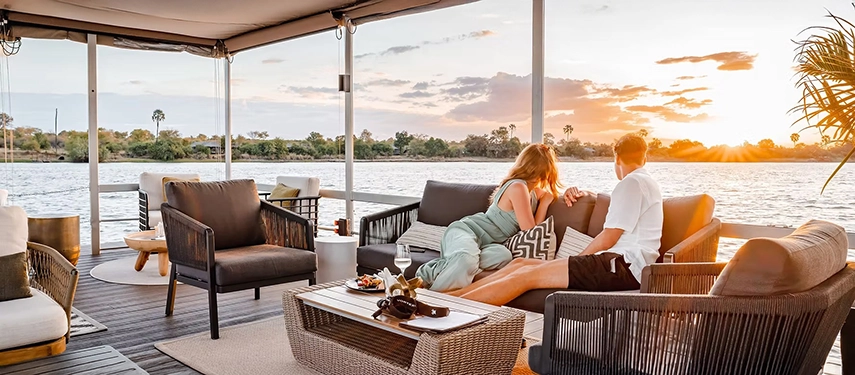 A private riverfront deck at Insika Lodge offers relaxed seating and sunset views over the calm waters of the Zambezi.