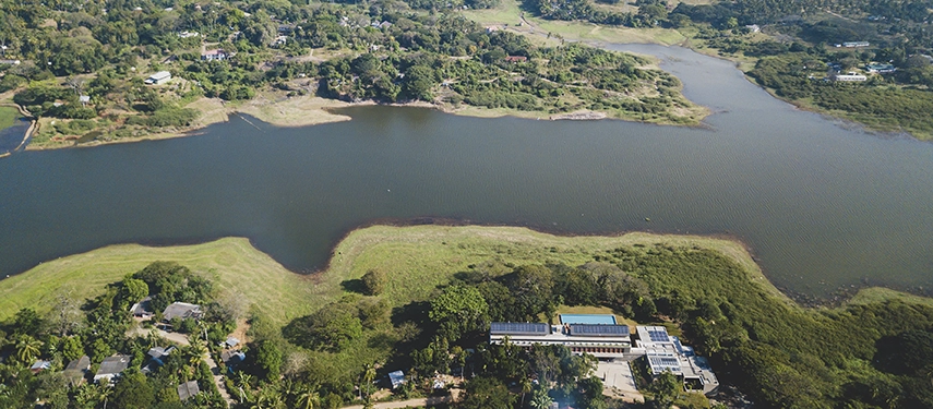 An aerial image shows Jetwing Kandy Gallery bordered by a wide river and expansive greenery stretching toward the horizon.