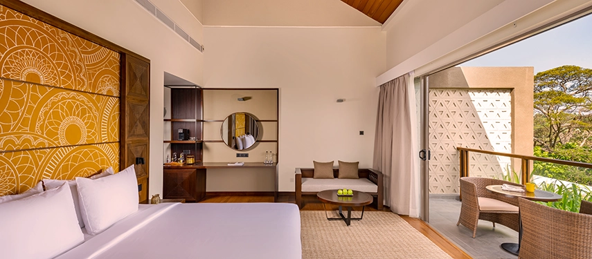 A refined room at Jetwing Kandy Gallery features soft earthy tones, a stylish desk area and a balcony overlooking the surrounding greenery.