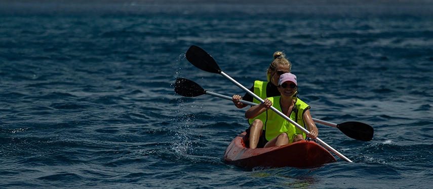 Guests kayaking through calm blue waters near the Hermes Galápagos Mega Catamaran.