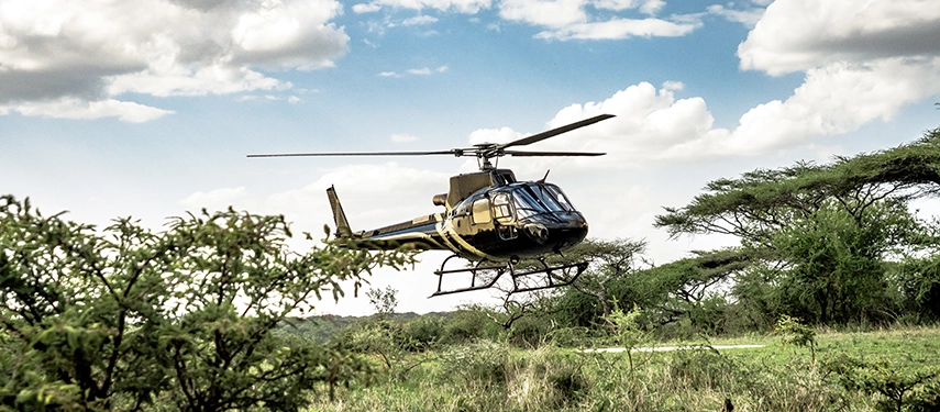 Helicopter landing near Legendary Lodge in Arusha, highlighting seamless scenic transfers and aerial access to Tanzania’s iconic safari destinations.