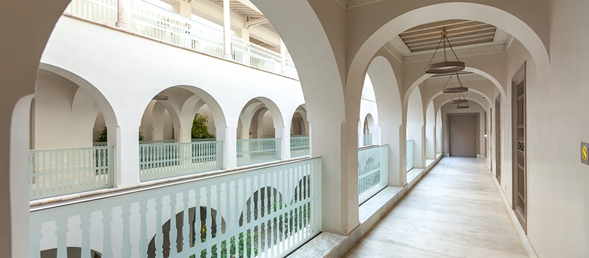 Stylish hallway with arched niches, modern artwork, and wooden accents leading into the hotel interior.