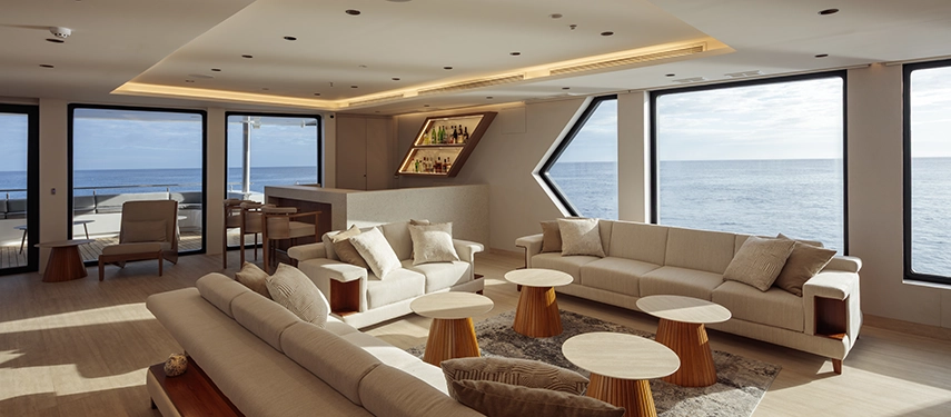 Contemporary lounge and bar with panoramic sea views on the Hermes Galápagos Mega Catamaran.