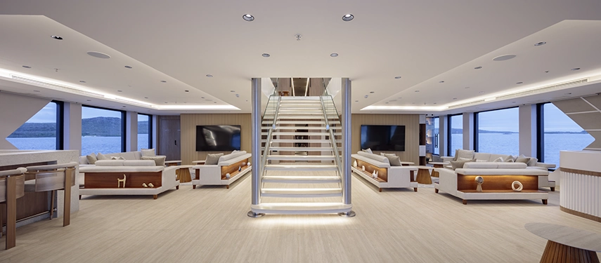 Elegant central lounge and staircase with wide sea views on the Hermes Galápagos Mega Catamaran.