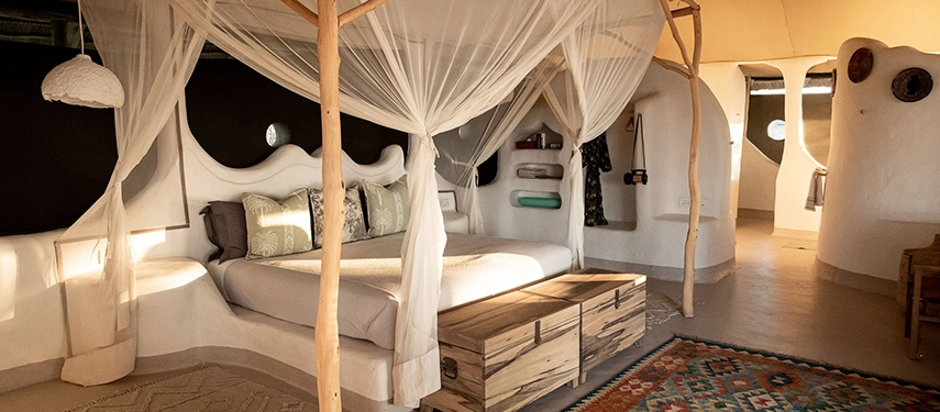 A sculptural, earth-toned bedroom at Moela combines organic design with refined comfort on the edge of the Makgadikgadi.