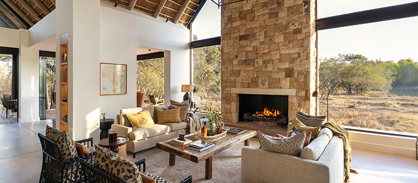 Evening dining setup with fire pit and lanterns, creating an intimate outdoor atmosphere beneath the trees.