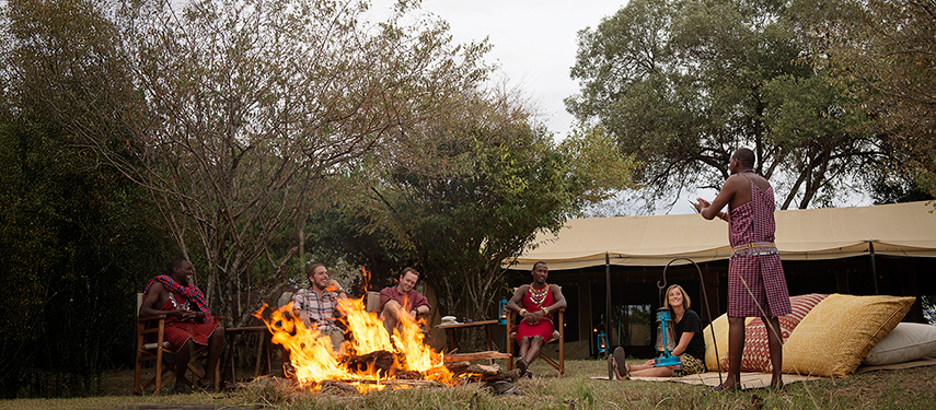 The shared mess tent at Nkorombo with elegant furnishings, a white sofa, and tribal artwork.