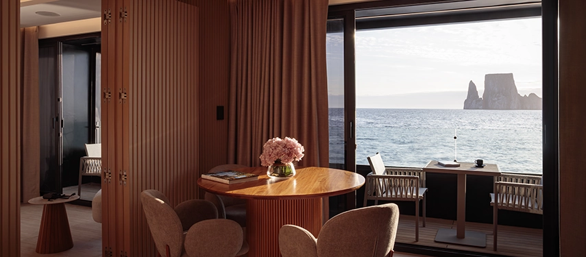 Luxurious bedroom with contemporary design and connecting living area on the Hermes Galápagos Mega Catamaran.