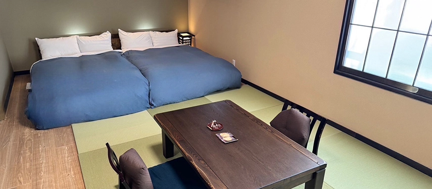 A Japanese-style guest room with tatami flooring and futon beds, offering a simple and restful ryokan experience.