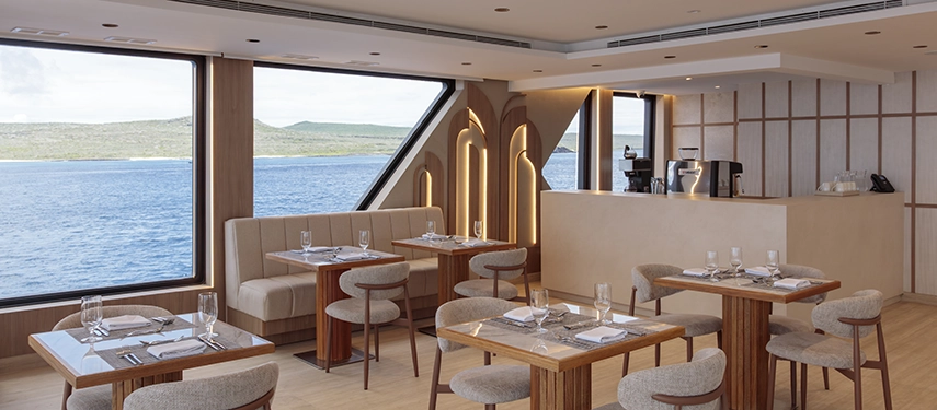 Restaurant with ocean-view windows and modern design on the Hermes Galápagos Mega Catamaran.