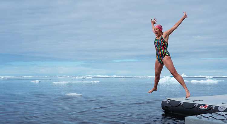 Woman leaping into the Antarctic ocean on Antarctica holidays