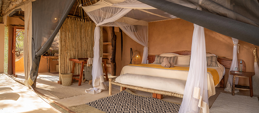 Elegant open-fronted guest suite with canopy bed and natural textures at Reteti House.